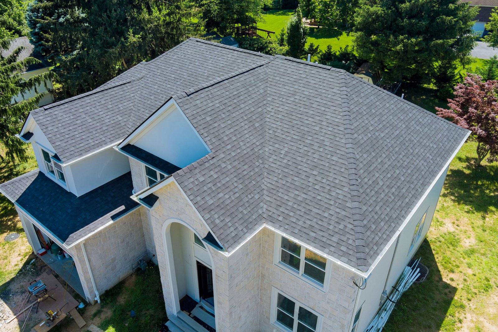 Aerial view of asphalt shingles roofing construction, the house with new window Aerial view of asphalt shingles construction site roofing the house with new window
